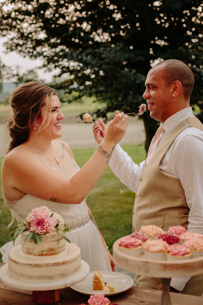Chef Heather and husband Josh exchanging bites of cake at their wedding
